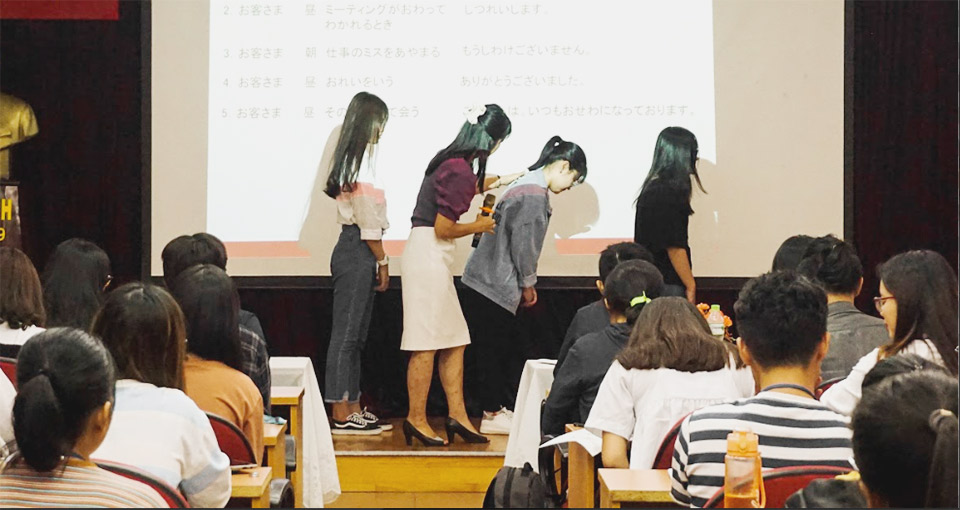 日本ビジネスマナー講座で正しいおじぎの仕方を習う大学生たち